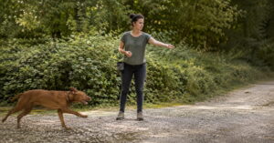 Frau und Hund beim 10 Leckerlispiel
